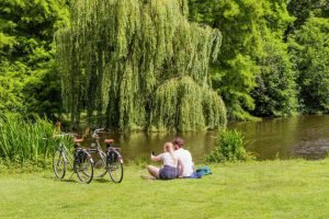 Een koppel die aan het genieten is in het vondelpark Amsterdam