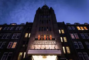 a large building with a clock tower lit up at night one of the romantic hotels in Amsterdam for your proposal