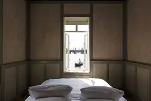 interieur of one of romantic hotels in Amsterdam for your proposal a large white bed sitting in a room