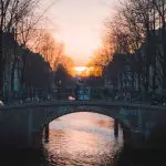 a bridge over a body of water with a city in the background