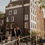 a man and a woman walking down a street next to a building