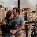 Happy couple at bridge and canalhousesing next to a bicycle